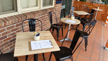 Photo showing several tabletops of different shapes made by the shed in use at a cafe
