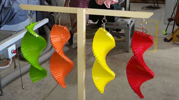 Photo showing several colourful wind spinners made by the shed
